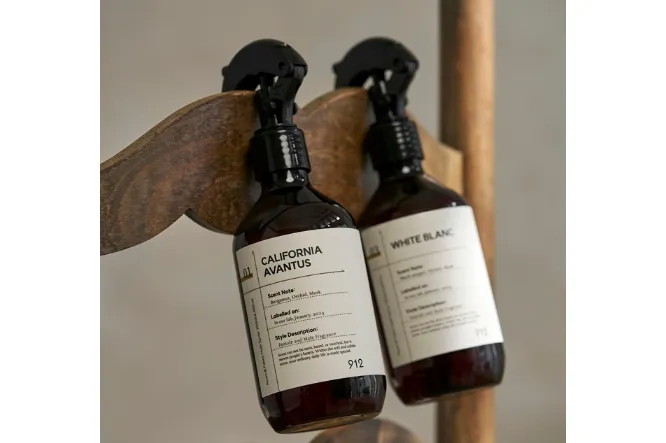 Two 912 mist bottles hanging on a wooden hook