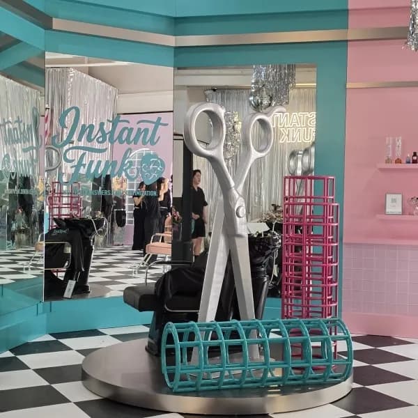 Salon-style store with a giant scissors sculpture and a checkered floor